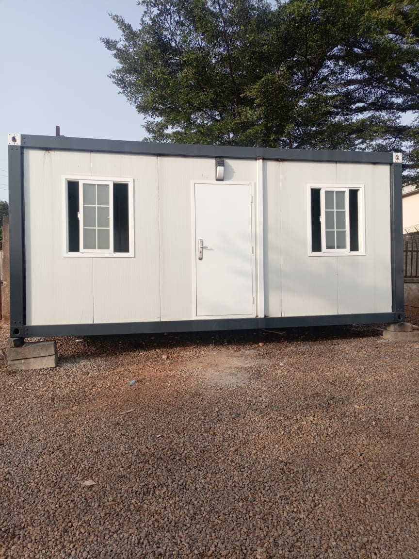 White porta-cabin with two windows and a steel door