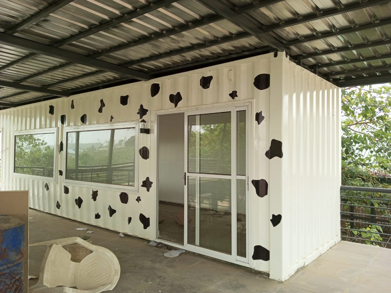 White container unit converted with sliding glass doors and wide windows