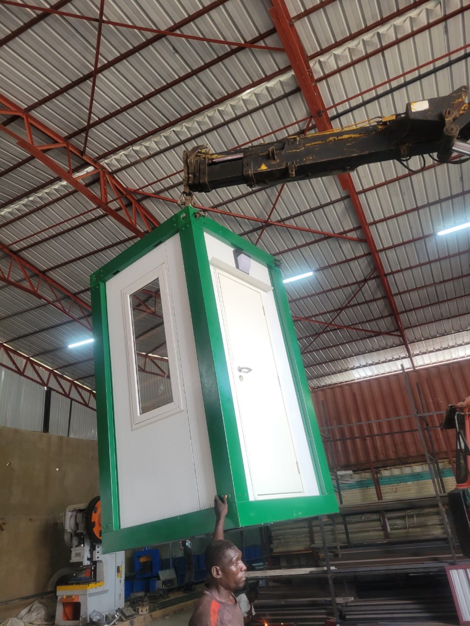 Green and white panel guard post lifted by crane in the workshop